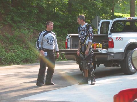 1985 Ford LTD Crown Victoria - Two men in motocross gear stand next to a white pickup truck with its tailgate down.