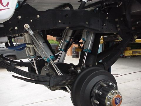 1984 Ford Bronco - This image shows the underside of a vehicle, focusing on its modified suspension system with multiple shock absorbers and leaf springs.