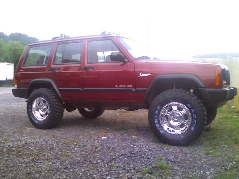 1998 Jeep Cherokee - This red 1998 Jeep Cherokee Sport is shown with aftermarket wheels and tires, and appears to be lifted.