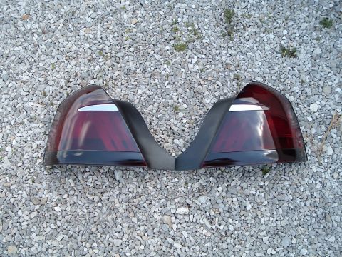 1999 Mercury Grand Marquis - Two red taillights with chrome accents are displayed on a gravel surface.