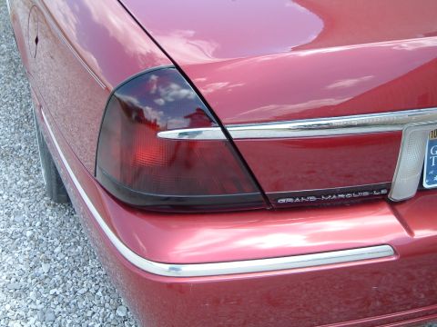 1999 Mercury Grand Marquis - Rear view of a red Mercury Grand Marquis LS, showing the taillight and chrome trim details.