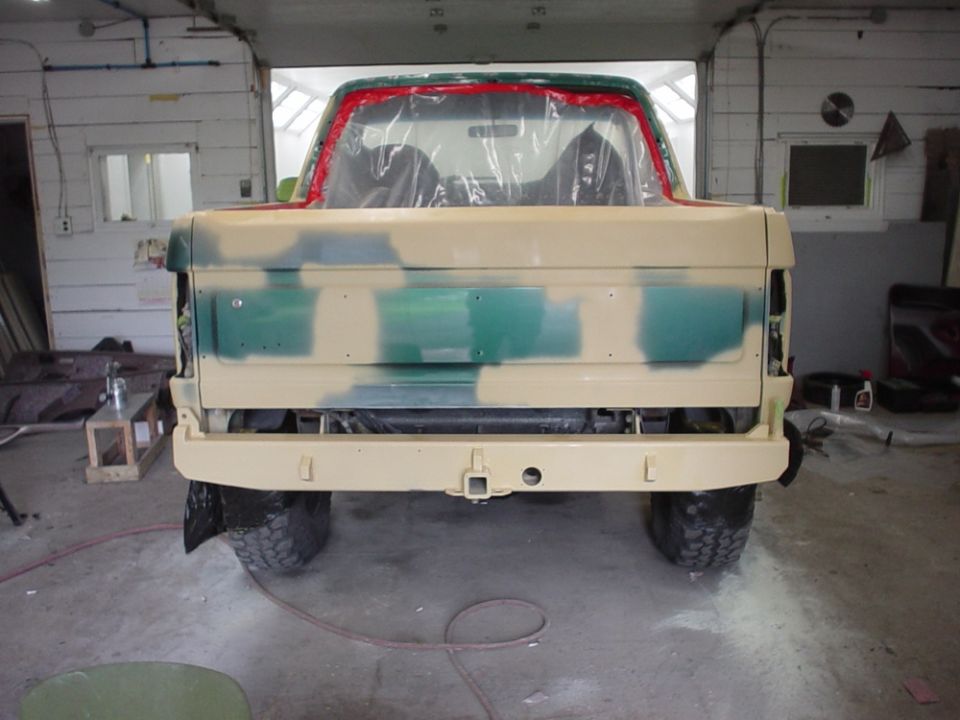 1996 Ford Bronco rear view, covered in primer and green paint, in a garage