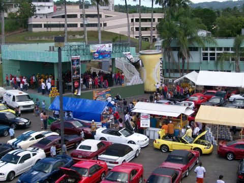 2001 Ford Mustang - A car show multiple Ford Mustangs, including a yellow convertible.