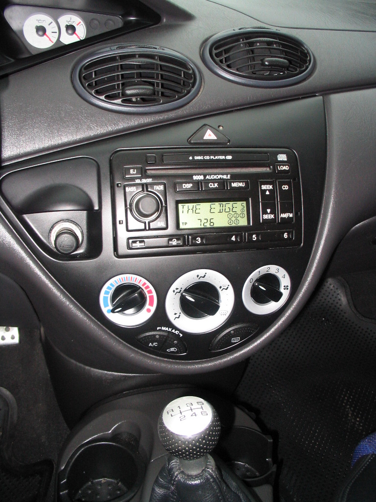 Dashboard of a 2003 Ford Focus with radio, climate controls, and manual shifter