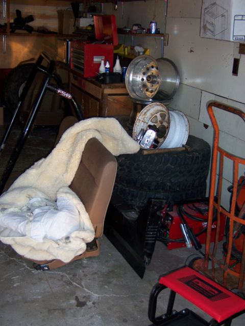 1991 Ford Bronco - A cluttered garage scene with various automotive parts and equipment visible.