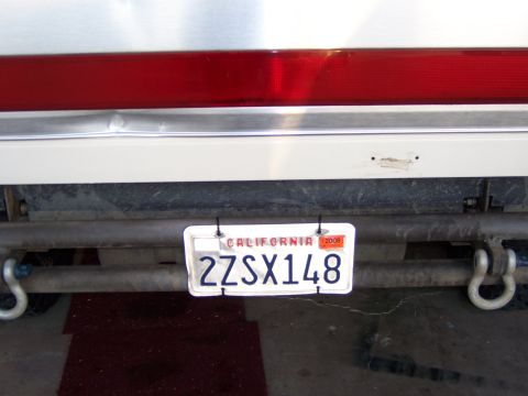 1991 Ford Bronco - A close-up view of a vehicle's rear bumper, showing a California license plate and tow hooks.