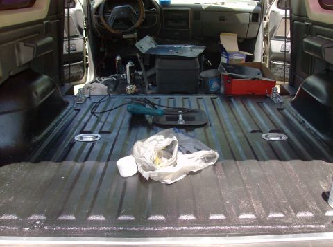 1989 Ford Bronco - The interior of a vehicle is shown, with a focus on the cargo area and the dashboard.