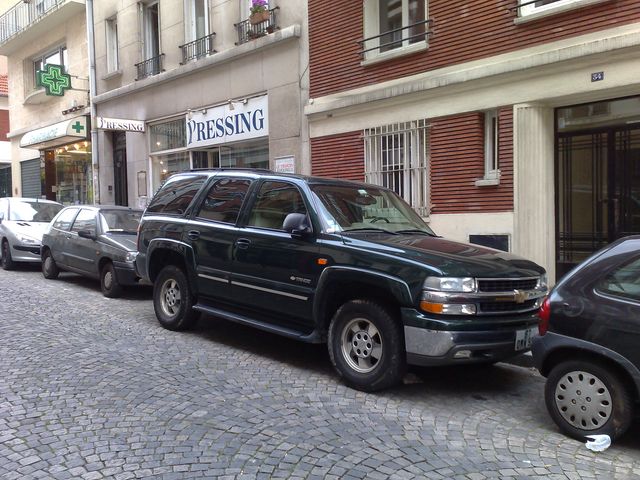 Dark green Chevrolet Tahoe parked on cobblestone street
