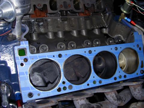1972 Ford Ranchero - Close-up of an engine block during repair, showing pistons and a new gasket being installed.
