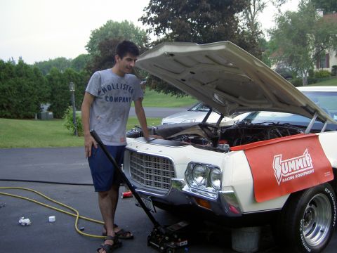 1972 Ford Ranchero - Man works on a 1972 Ford Ranchero, engine bay open. A second vehicle is parked behind.