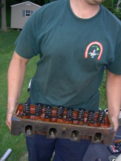 1972 Ford Ranchero - Engine cylinder head with valves and springs visible, held by a person outdoors.