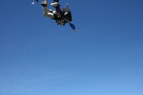1996 Ford Bronco - Two people are skydiving together against a bright blue sky.