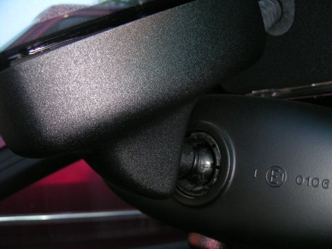2002 BMW M3 - Detail of a vehicle's interior rear view mirror mount, showing regulatory markings and a website watermark.