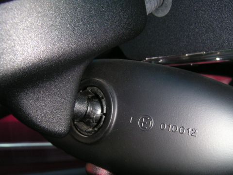 2002 BMW M3 - Close-up of a vehicle's interior rear view mirror assembly shows regulatory markings and a website watermark.