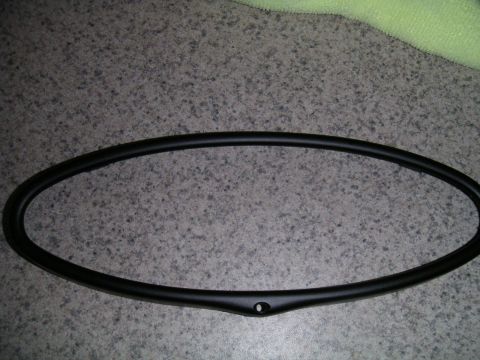 2002 BMW M3 - A black gauge cluster bezel, likely for an interior component, is shown against a speckled countertop.