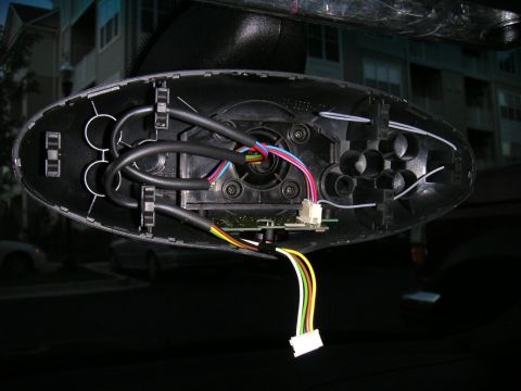 2002 BMW M3 - Internal components of a car's rear view mirror housing are exposed, revealing wires and a circuit board.