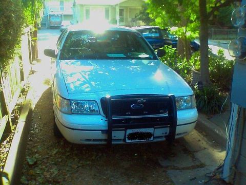 2000 Ford Crown Victoria - This white 2000 Ford Crown Victoria is equipped with a black push bar and is parked in a driveway.