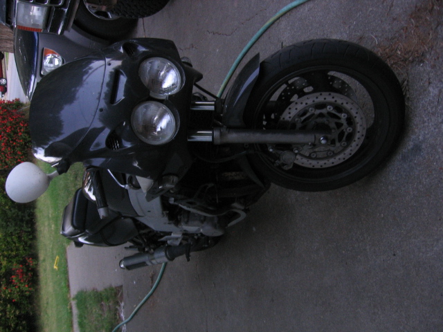 Black sportbike at a front three-quarter angle with twin round headlights