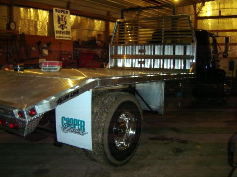1992 Ford Bronco - Custom flatbed truck with 'Cooper Service' branding on the mud flap, seen in a workshop.