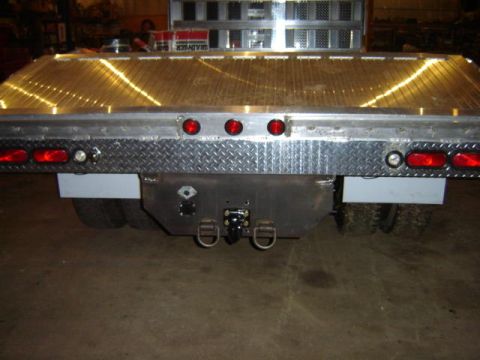 1992 Ford Bronco - This flatbed truck features a diamond plate bumper and multiple trailer hitch receivers.