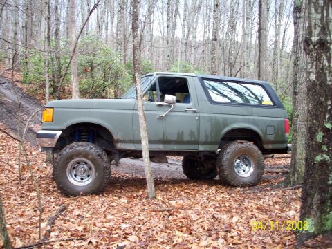 1987 Ford Bronco - This lifted 1987 Ford Bronco is parked on a wooded trail during autumn.