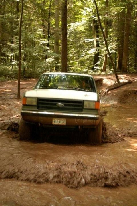 1987 Ford Bronco - This 1987 Ford Bronco navigates a challenging muddy off-road path.