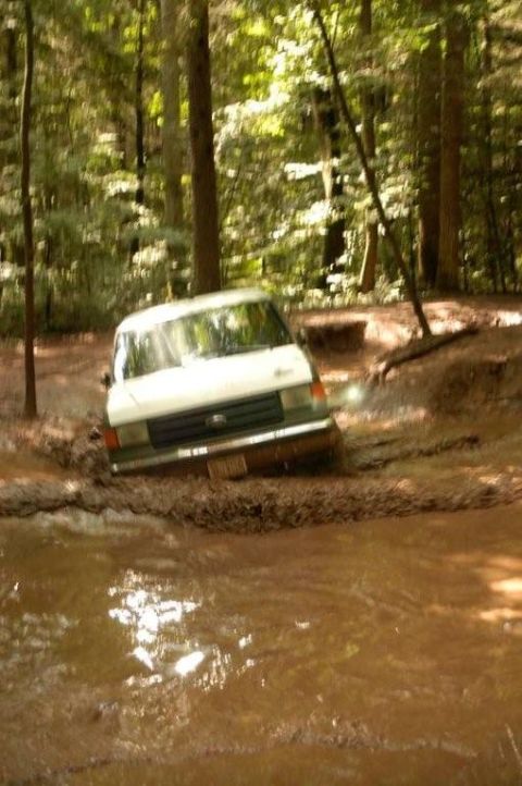 1987 Ford Bronco - This 1987 Ford Bronco is navigating a muddy trail through a forest.