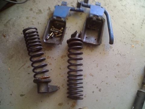 1971 Ford Bronco - Coil springs and associated hardware are laid out on a concrete surface, likely for repair or replacement.