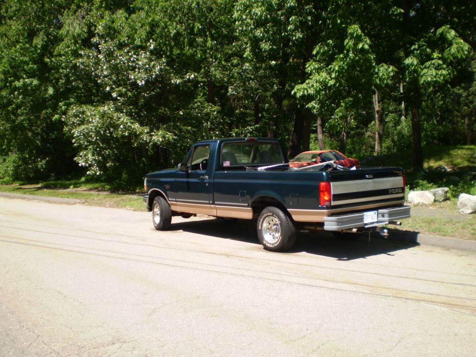 1995 Ford F-150 pickup truck parked on a paved road, side view