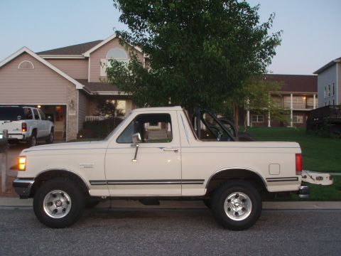 1987 Ford Bronco - This 1987 Ford Bronco is shown from the side, parked in front of a residential building.