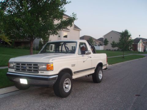 1987 Ford Bronco - This 1987 Ford Bronco is captured in a three-quarter front view on a residential street.