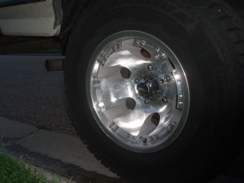 1987 Ford Bronco - Close-up of a vehicle's wheel and exhaust pipe, with a watermark for Supermotors.net visible.
