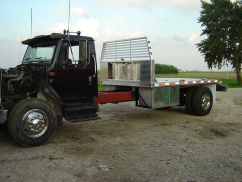 1992 Ford Bronco - A black flatbed truck is shown from the front with its engine compartment open.