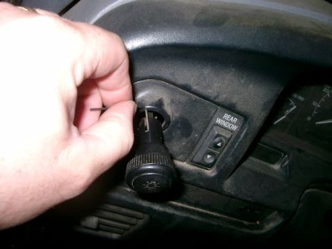1995 Ford Bronco - Close-up of dashboard controls, including a light switch and rear window buttons.