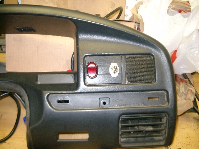 Removed gray Ford dash bezel on bench with added red rocker switch and chrome toggle