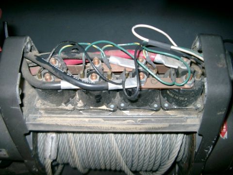 1995 Ford Bronco - Close-up view of a winch's internal wiring and components, showing electrical connections and a wound steel cable.