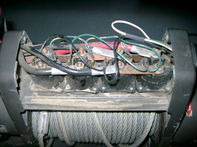 Winch mechanism with visible wiring, solenoids, and steel cable spool. Made in USA label visible