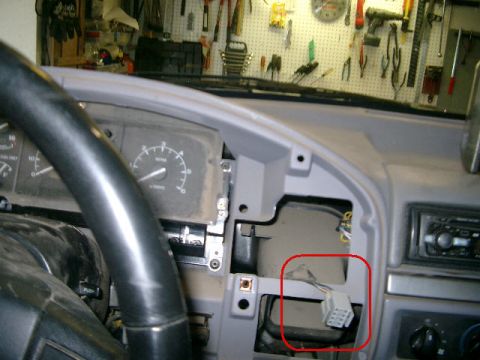 1995 Ford Bronco - Close-up of a vehicle's interior dashboard, highlighting a wiring harness within a red circle.