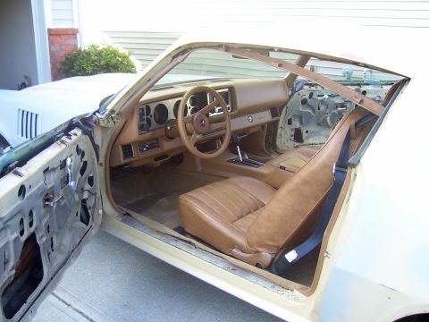 1979 Chevrolet Camaro - Interior view of a 1979 Chevrolet Camaro showing tan seats and removed door panels.