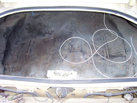 1979 Chevrolet Camaro - The interior of an empty car trunk shows some wear and tear, with loose wiring visible.