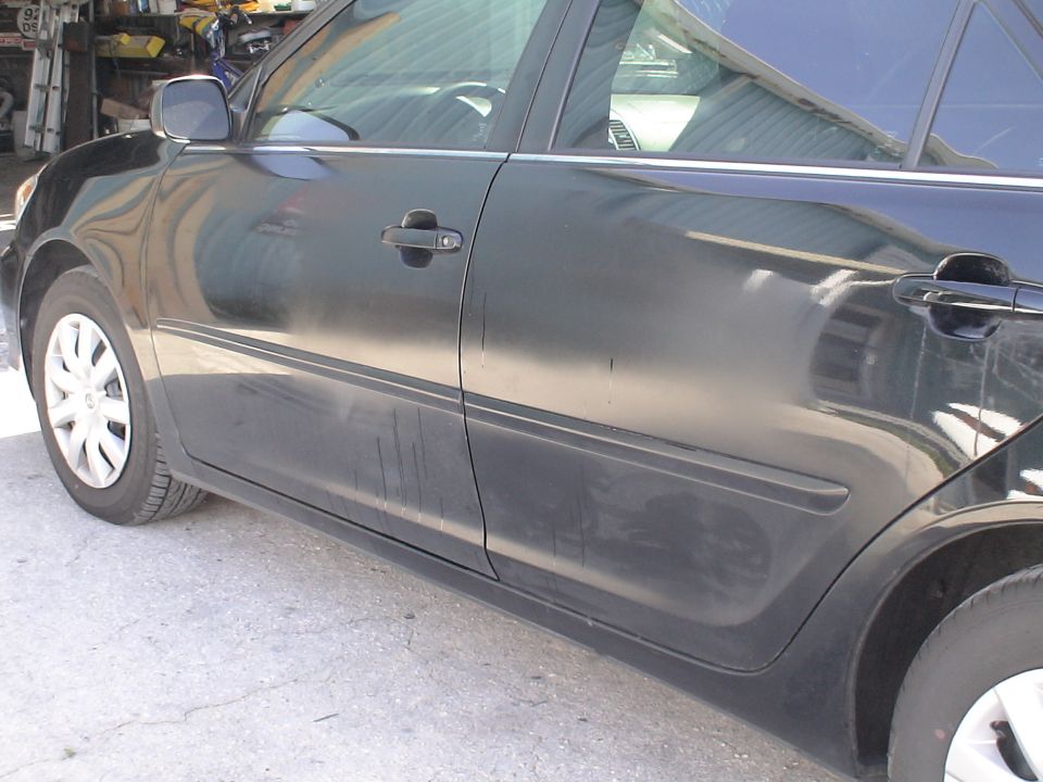 Side view of a black sedan's doors and front wheel