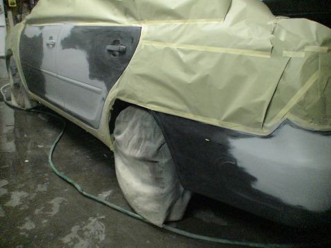1993 Ford C-350 (Centurion Conversions) - A car is being prepped for painting, with sections taped off and sanded.