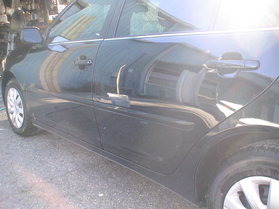 Side view of a black car showing the doors and rear fender