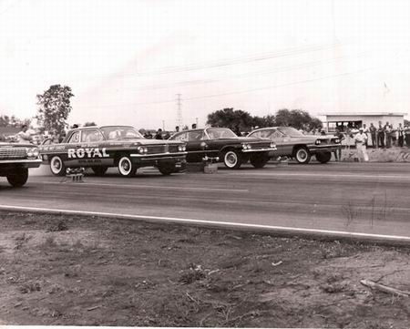 1972 Ford Ranchero - Multiple cars are lined up at a drag strip, with spectators watching from the side.