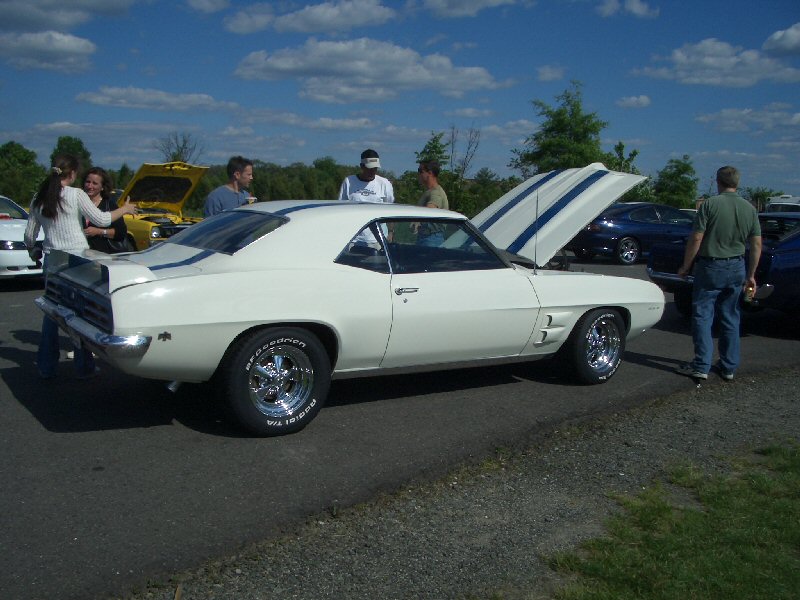 White 1969 coupe with blue racing stripes on hood and trunk, chrome wheels, hood open
