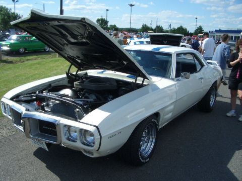 1970 Ford Mustang - This white 1969 Pontiac Firebird is displayed with its hood open, revealing the engine bay.