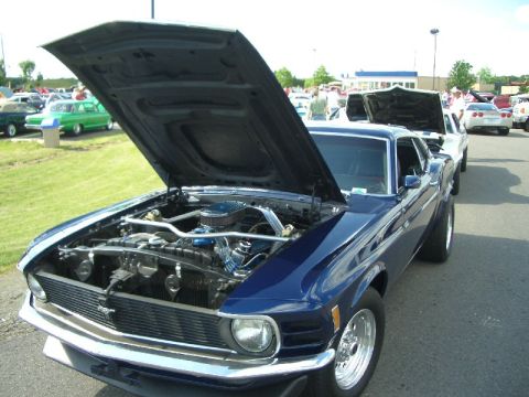1970 Ford Mustang - Dark blue 1970 Ford Mustang at a car show, hood raised to display the engine.