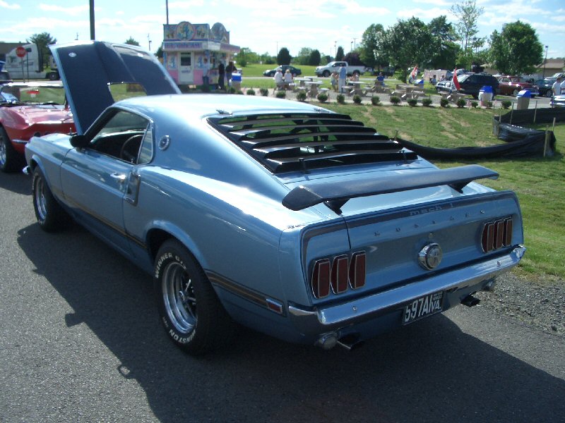 Blue 1969 Mustang Mach 1 with hood open, louvers on rear window, and spoiler