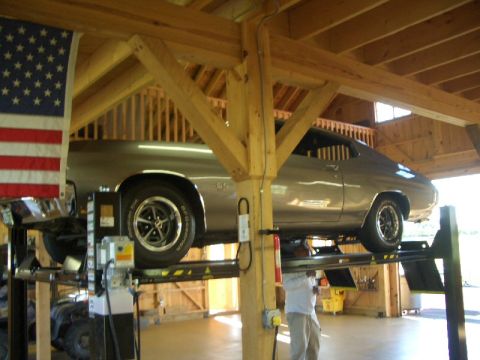 1970 Ford Mustang - A silver 1970 Chevrolet Chevelle SS is raised on a car lift inside a wooden structure.