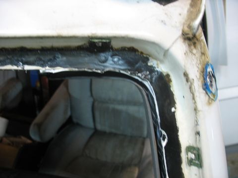 1995 Ford C-350 (Centurion Conversions) - Close-up view of a vehicle's windshield frame and interior, showing sealant and upholstery.